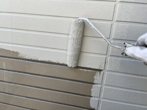 外壁中塗り作業中。下塗り後にプレミアムシリコンを重ね、塗膜の厚みとツヤを出しています（東近江市G様邸）。