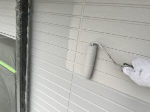 東近江市G様邸の外壁上塗り作業。アイボリー系のプレミアムシリコンでツヤと防汚性を仕上げています。