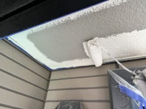 東近江市G様邸 軒天下塗り作業。ローラーで広い面を均一に塗布し、下地を整えています。