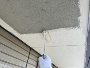 東近江市G様邸 別箇所での軒天下塗り作業。ローラーでムラなく塗り、後の中塗り・上塗りがしっかり密着するよう仕上げています。